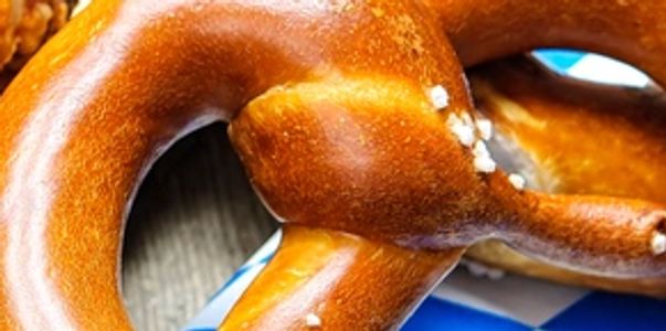 Close-up of a freshly baked soft pretzel with coarse salt.