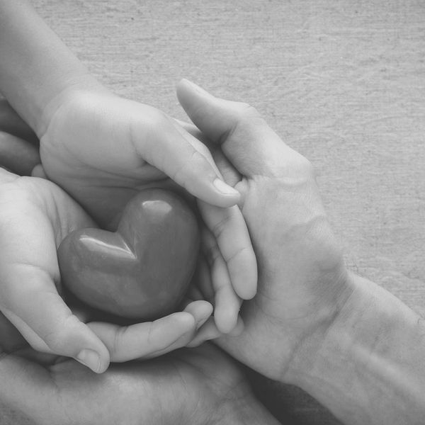 Two peoples hands holding a heart