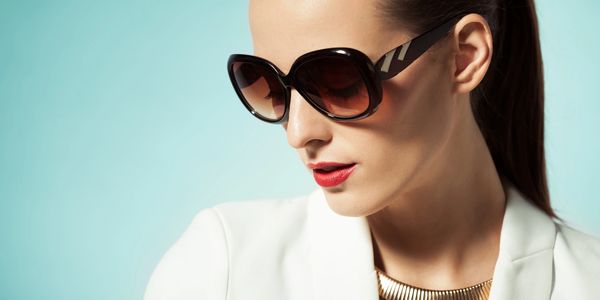 Woman wearing large sunglasses and red lipstick.