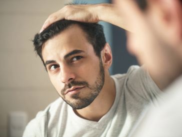 Man checking his hair in the mirror.