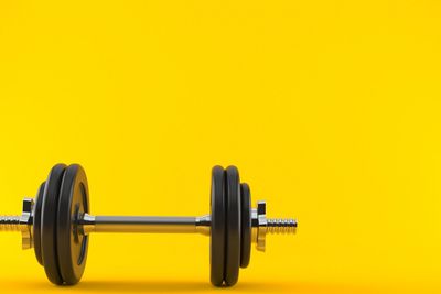 Dumbbell on a yellow background