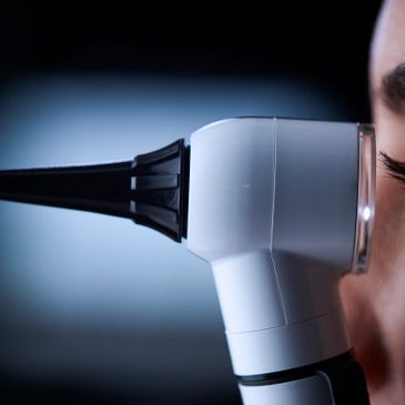 Close-up of an ear examination using an otoscope on a person's ear.