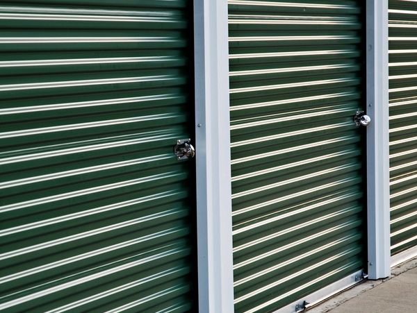 Row of green storage unit doors with locks.