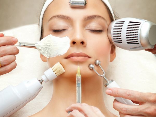 Woman receiving multiple facial treatments simultaneously at a spa.
