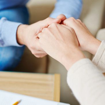 Someone holding a woman's hands in support for Givelist project to assist at-risk women and youth.