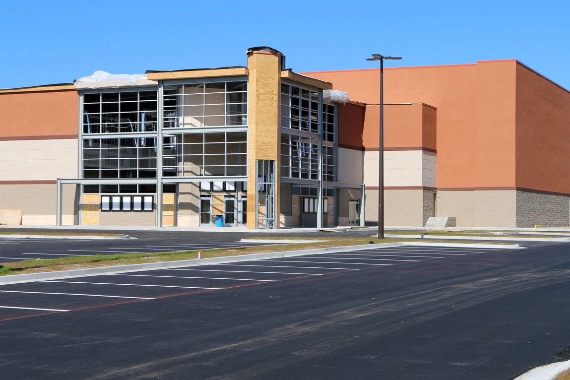 New commercial building under construction with empty parking lot.