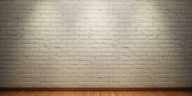 Empty brick wall with wooden floor under spotlight.