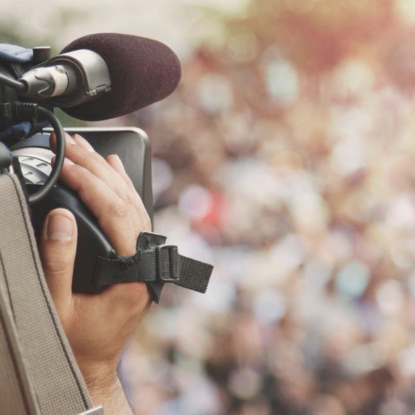 Close-up of a person filming with a professional video camera.