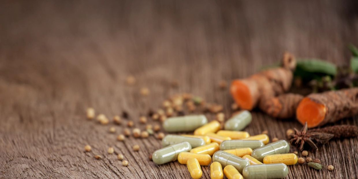 Herbal medicine capsules with turmeric roots.
