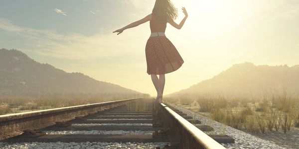 Woman balancing herself on road of life