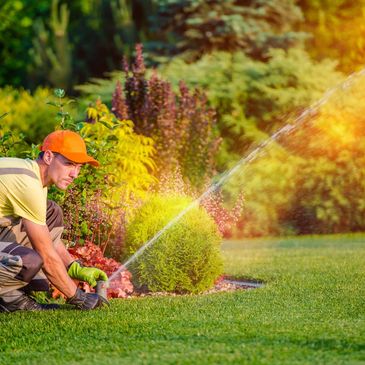 Man adjusting sprinkler.