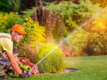 Irrigation technician adjusting nozzle for proper coverage to create a beautiful landscape.