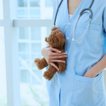 una doctora sosteniendo un oso de peluche
