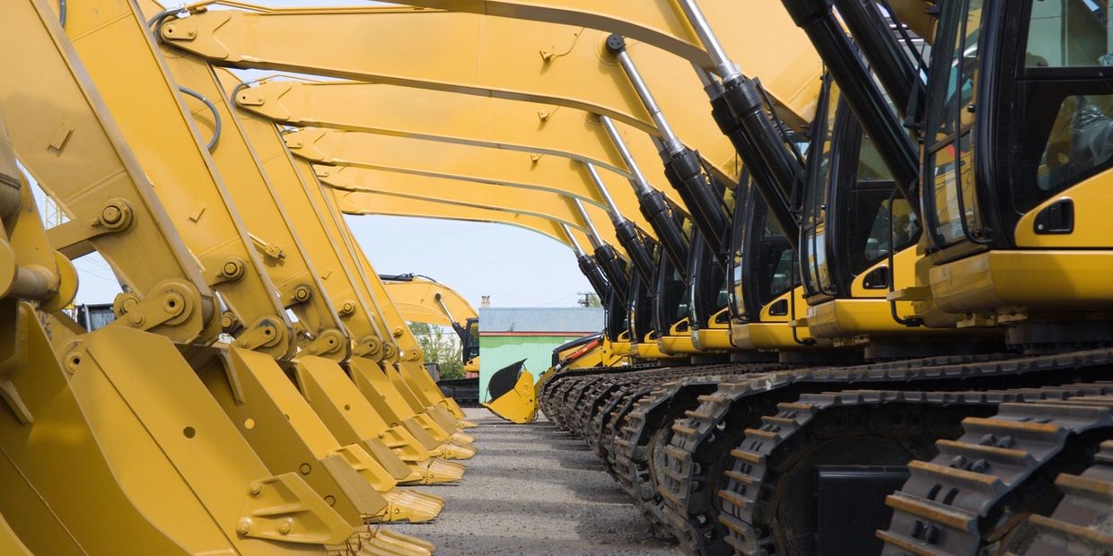 Rows of yellow excavators parked facing each other.