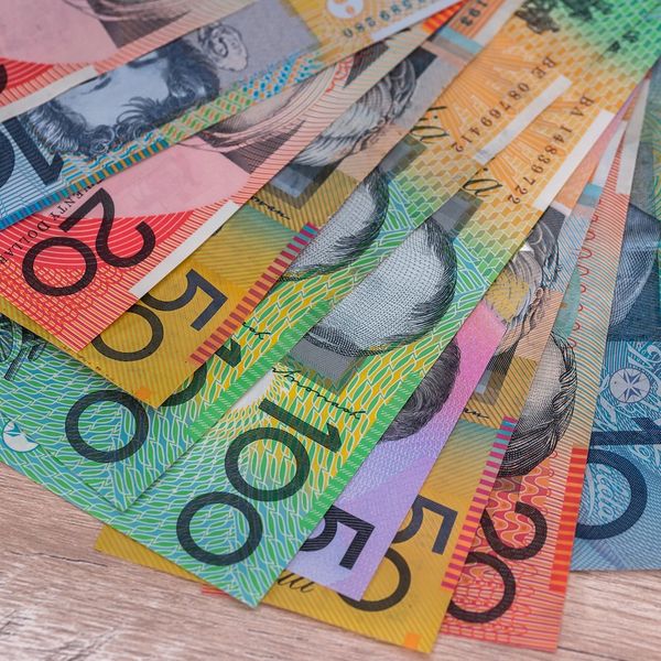 Colorful Australian dollar banknotes spread out on a wooden surface.