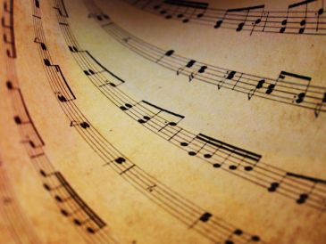 Curved sheet music with musical notes on aged paper.