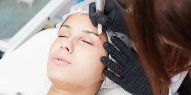A woman receiving a cosmetic eyebrow treatment.