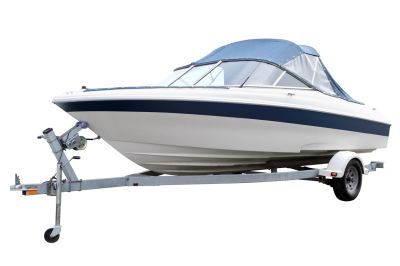 White and blue motorboat on a trailer with a blue canopy.