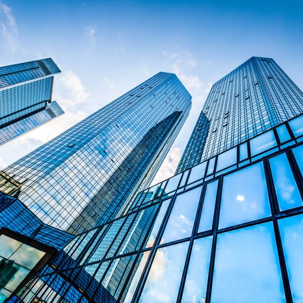 Modern glass skyscrapers against a blue sky.