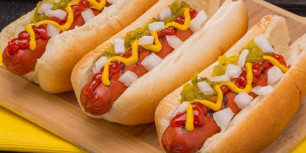 closeup shot of three hot dogs on a plate 