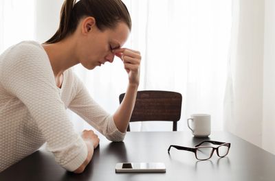 tired woman sitting at table 