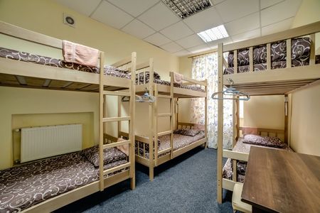 A cozy hostel room with wooden bunk beds and simple decor.