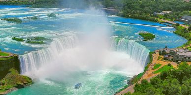 An aerial view of Niagara Falls and a tour bus driving near it on the road