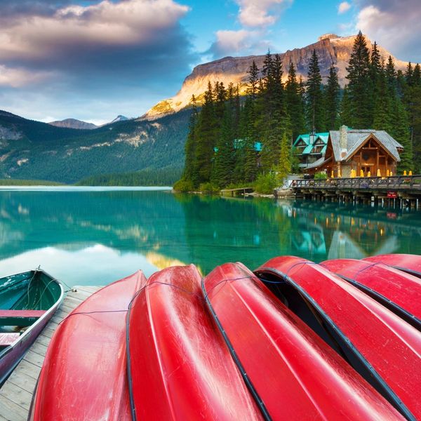 Canoes on a mountain lake with a cabin in the background.