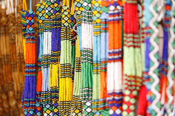 Colorful beaded necklaces hanging in a row, showcasing intricate patterns.