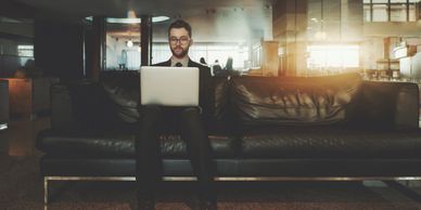 Hombre sentado con su laptop haciendo crecer su negocio con Be Smart