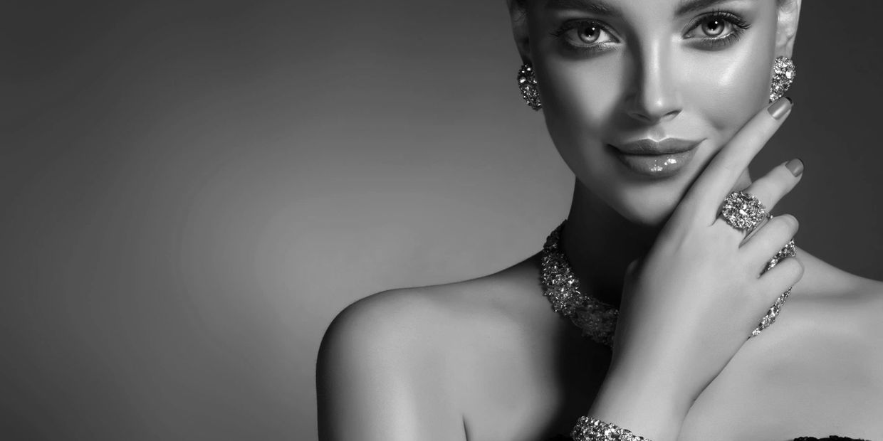 Black and white portrait of a woman adorned with elegant jewelry.