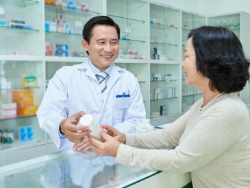 Pharmacist consulting a customer with prescription medicine.