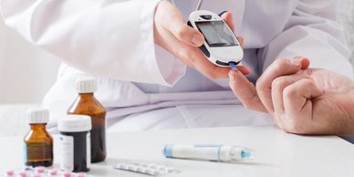 Medical professional checking a patient's blood sugar with a glucose meter.