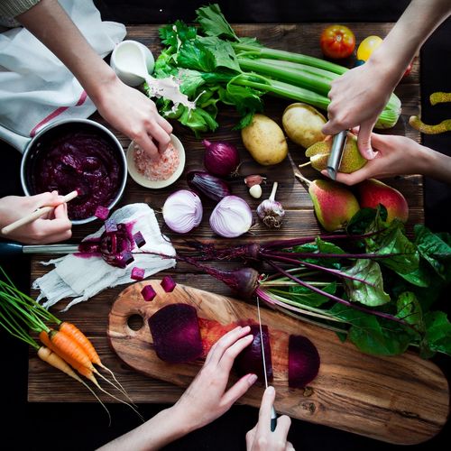 Group of people preparing vegetables and fruit.