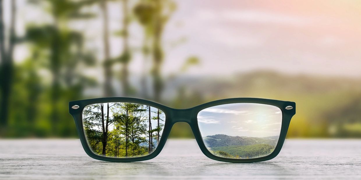 black glasses with a view of a mountain range sunrise