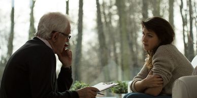 Male psychiatrist speaking with female patient. 