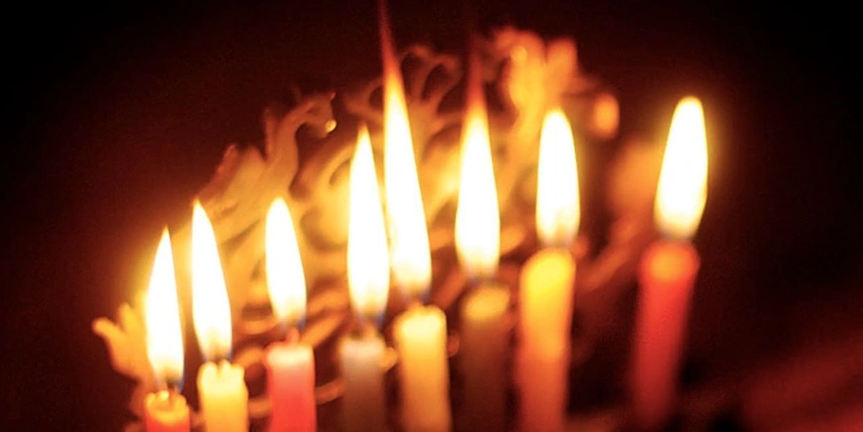 Lit candles glowing softly in a dark setting.
