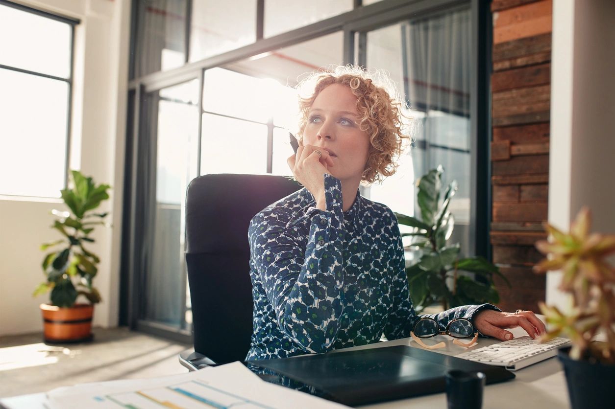 A worker brainstorms on her accomplishments and continued growth and development at her desk.