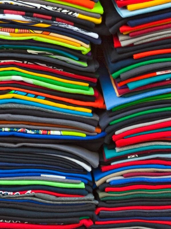 A pile of brightly coloured tee shirts ready for tee shirt printing