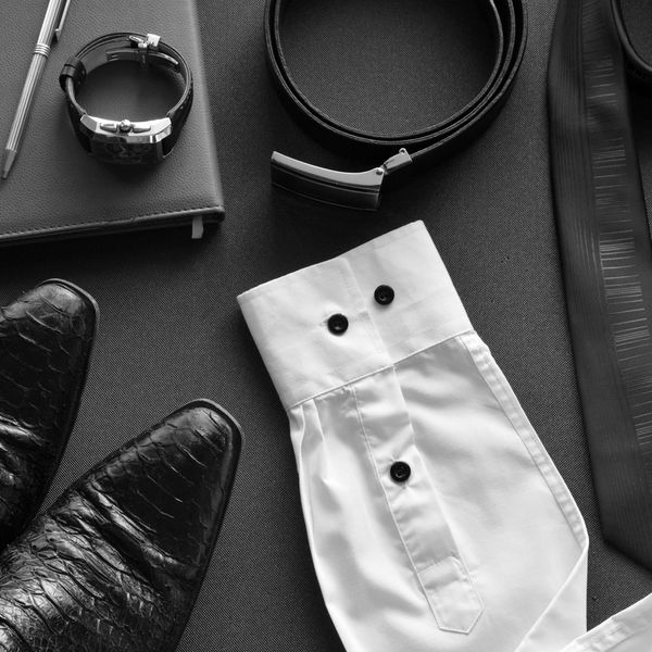 Men's formal accessories including shoes, watch, belt, shirt cuff, and tie.