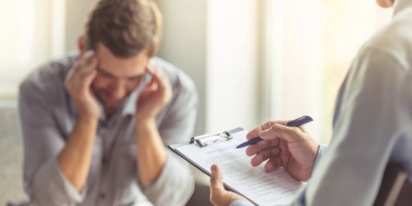 A person visibly stressed during a therapy session.