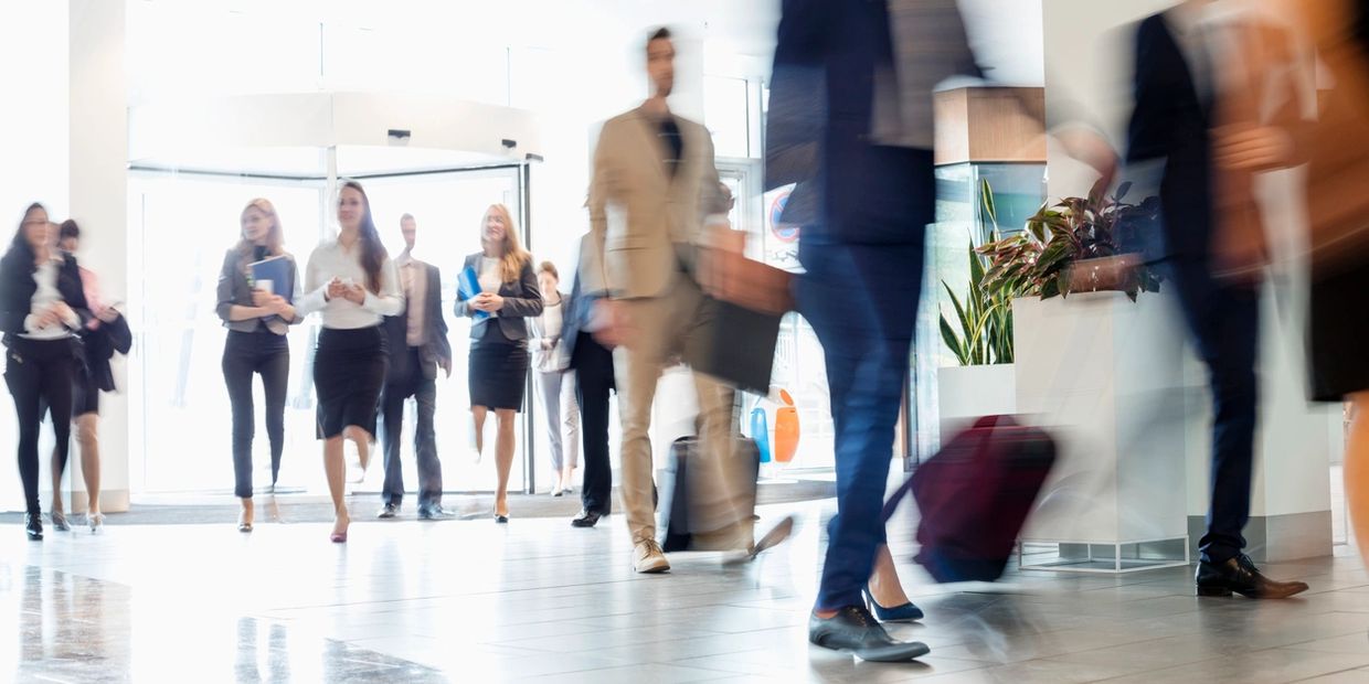 Commuters passing through a lively lobby space.