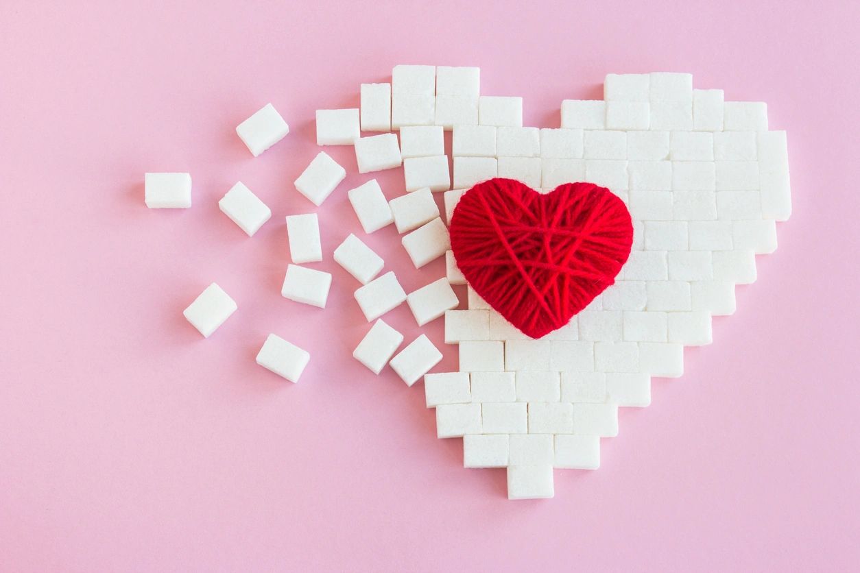 Red wool heart placed on sugar cubes arranged in a heart design