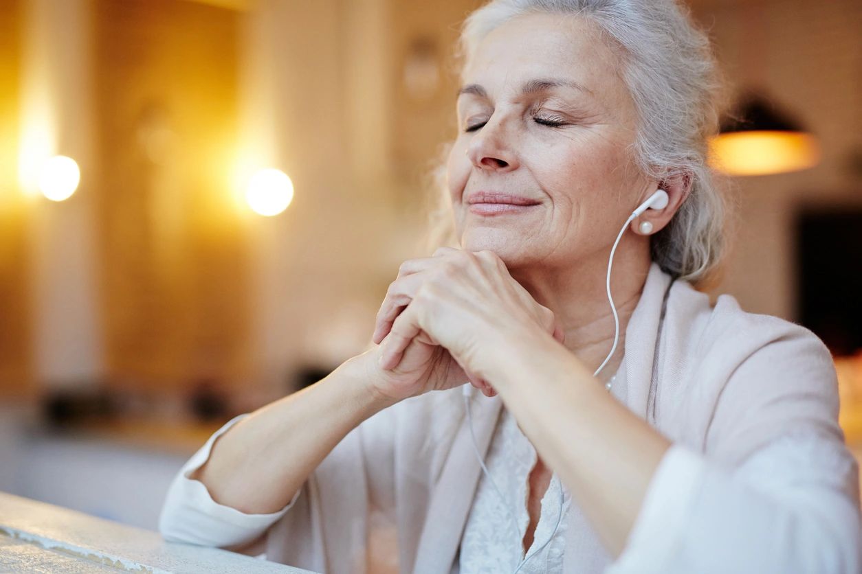 Older lady listening to Self-Talk from the Scriptures Bible Affirmations through her ear pods. 