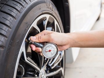 Auto technician checking tire air pressure.