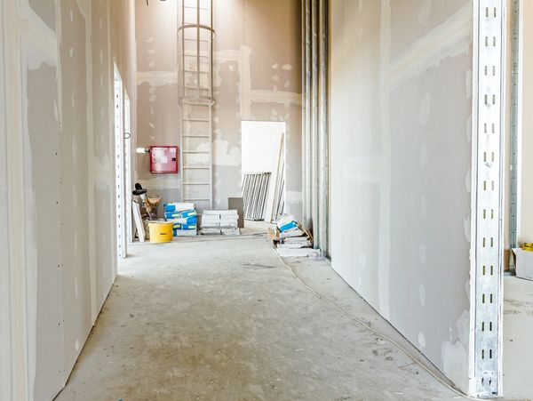 Interior of an unfinished building with construction materials and equipment.