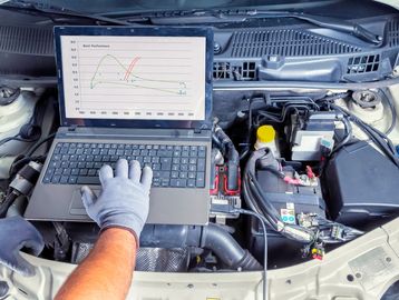 Vehicle technician using diagnostic equipment on a vehicle 