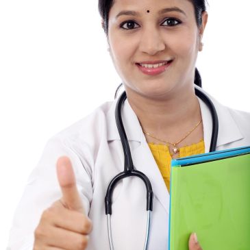 Female doctor giving a thumbs-up, holding folders, smiling confidently.