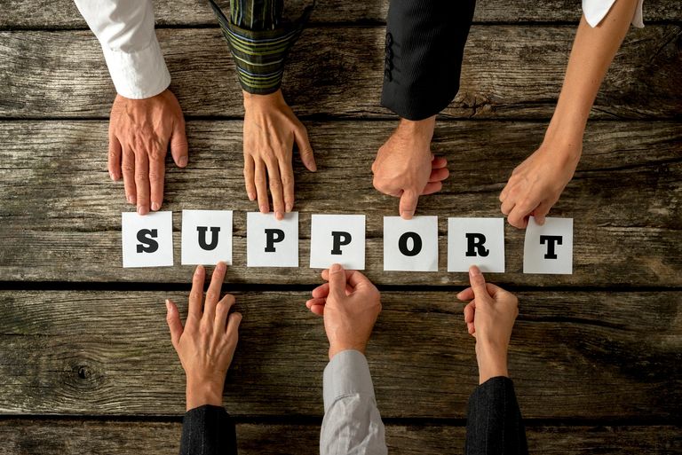 Hands holding letters on cards, spelling out the word support