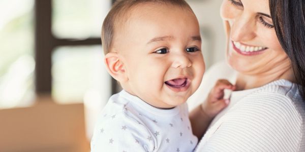 smiling mother holding smiling baby